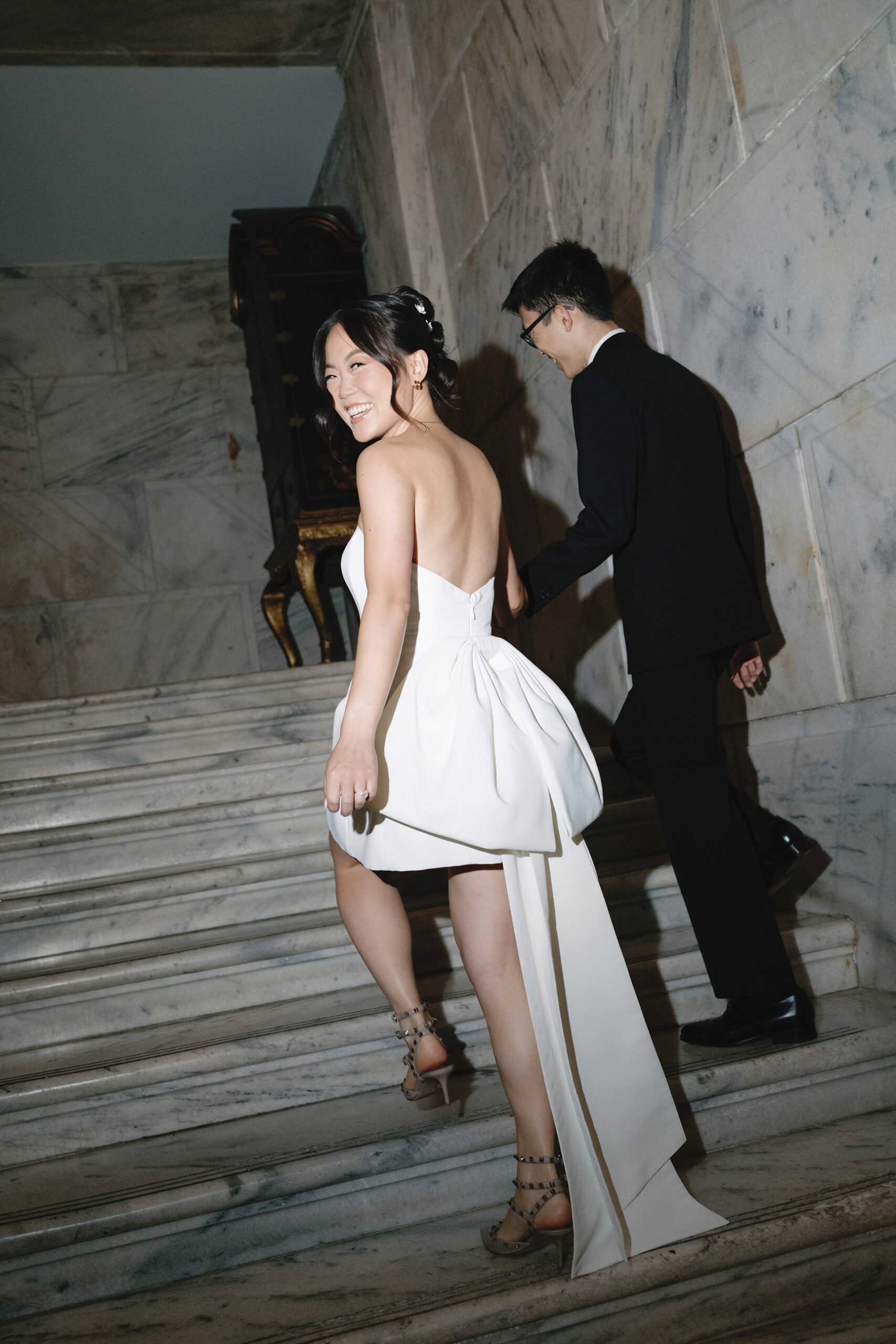 Chic newly married couple ascends the marble staircase at the Ritz Carlton in Philadelphia