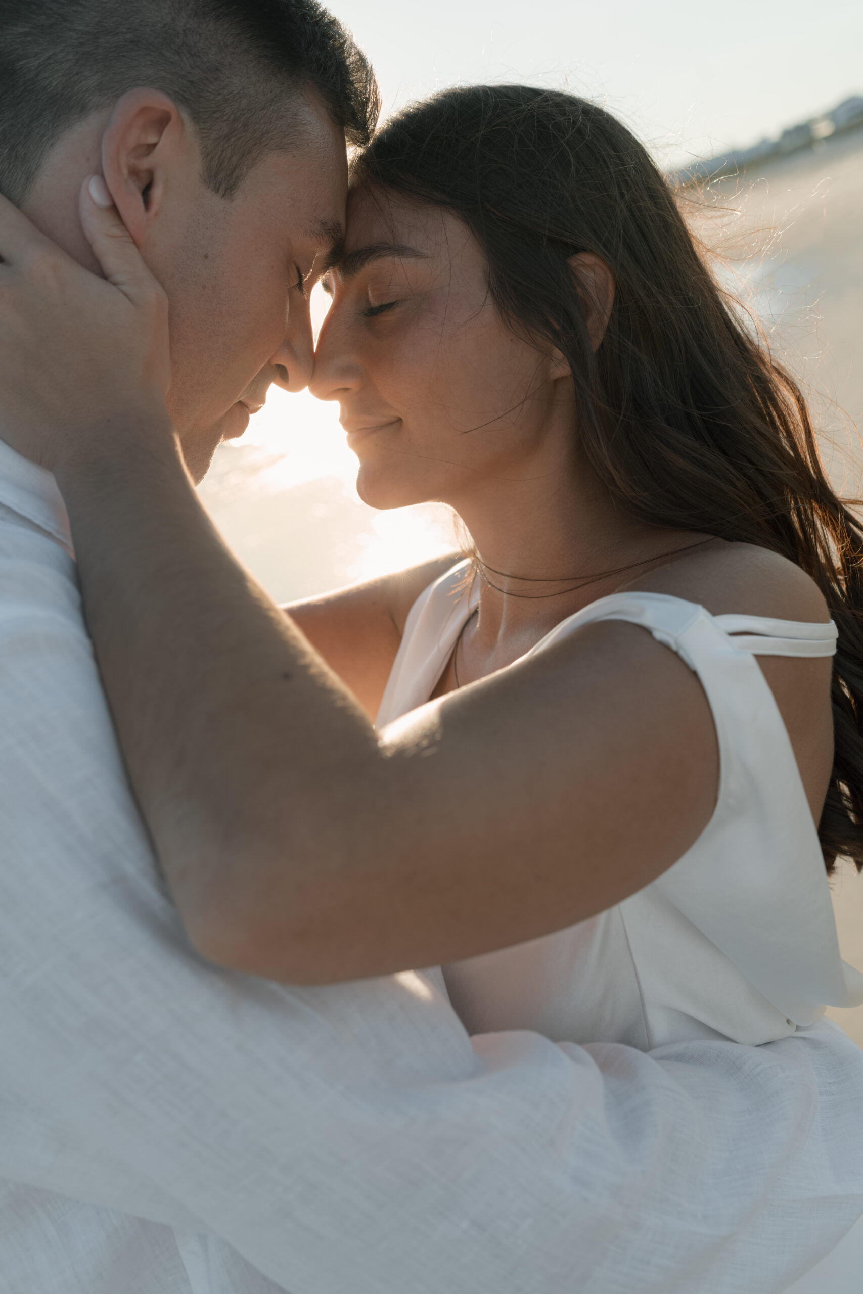 Couple embracing at golden hour on the beach during their Cape May engagement session